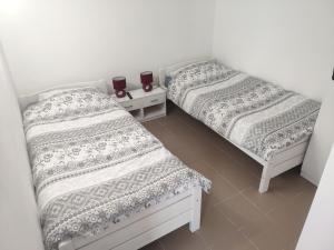 two beds sitting next to each other in a room at Apartments INBOX in Kostrena