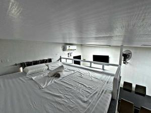 a large white bed in a room with a television at M&R Properties Philippines Lots 20 & 21 Interconnecting Units Bangad Cabanatuan City NE 3100 in Bangad