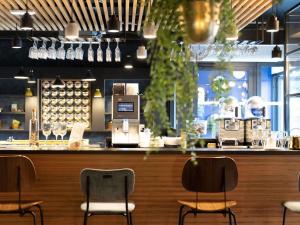een bar met drie stoelen aan een balie bij ibis Styles Dreux Centre Gare in Dreux