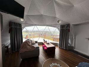 ein Wohnzimmer mit Couch und großem Fenster in der Unterkunft La cabaña de Ciela G glamping con jacuzzi y croquet in Latacunga