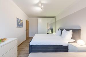 een slaapkamer met een groot bed met witte lakens bij Ferienwohnung Erika in Dassow