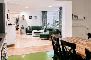 a living room with a green couch and a table at LichtLoft Pirna Altstadt mit 4 Schlafzimmer und XXL Wohnküche in Pirna