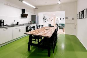 a kitchen with a wooden table and green flooring at LichtLoft Pirna Altstadt mit 4 Schlafzimmer und XXL Wohnküche in Pirna