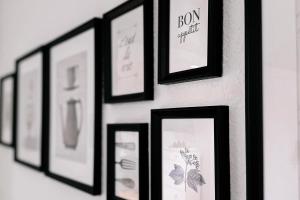 a group of framed pictures hanging on a wall at LichtLoft Pirna Altstadt mit 4 Schlafzimmer und XXL Wohnküche in Pirna