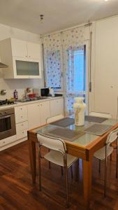 a kitchen with a wooden table with chairs and a table sidx sidx sidx at Le Caravelle in Mestre +15 photos