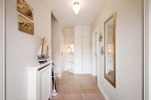 een hal met witte muren en een spiegel bij Alte Eiche in Utersum