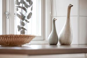 Twee witte vazen staan op een aanrecht naast een raam. bij Alte Eiche in Utersum