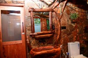 a stone bathroom with a toilet and a mirror at Eco Cabins Hideaway Ella in Ella