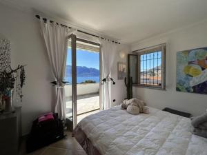 ein Schlafzimmer mit einem Bett, auf dem ein Teddybär liegt in der Unterkunft Villa with Panoramic Views in Oggebbio