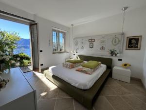 ein Schlafzimmer mit einem Bett und einem großen Fenster in der Unterkunft Villa with Panoramic Views in Oggebbio + 30 Fotos