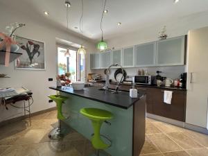 eine Küche mit einer Theke und einem grünen Hocker in der Unterkunft Villa with Panoramic Views in Oggebbio