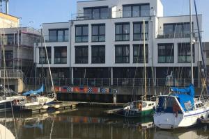 three boats docked in the water in front of a building at City Marina, CM22a in Cuxhaven