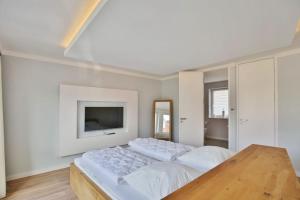 a bedroom with two beds and a tv on the wall at City Marina, CM22a in Cuxhaven