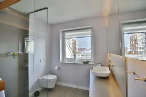a bathroom with a toilet and a sink and a window at City Marina, CM22a in Cuxhaven