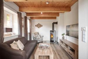 een woonkamer met een bank en een open haard bij Strandnest in Witsum