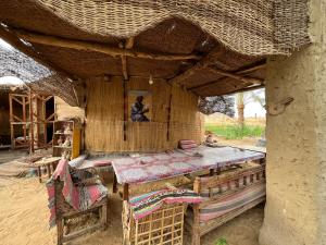 a room with a table and chairs in a hut at The Garden Under The Moon in Al Ḩayz