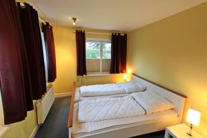 a bedroom with a white bed with a window at Ruhetal in Tinnum