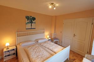 a bedroom with a large bed with two tables and two lamps at Ruhetal in Tinnum