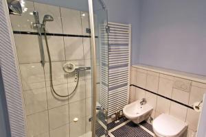 a bathroom with a shower and a toilet and a sink at Ruhetal in Tinnum +2 photos