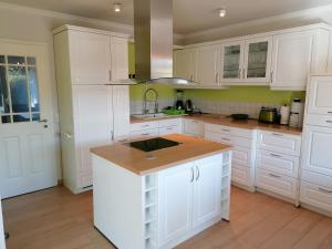 a kitchen with white cabinets and a wooden counter top at Stadthaus Lübsche Burg - ABC326 in Wismar