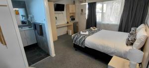 une chambre d'hôtel avec un lit et une cuisine avec une télévision dans l'établissement Kaputar Motel, à Narrabri