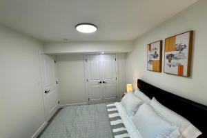 a bedroom with a bed with a black headboard at Sleek Guest Retreat SW EDM BSMT Suite in Edmonton