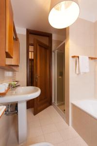 a bathroom with a sink and a shower and a toilet at Toti Apartment in Udine