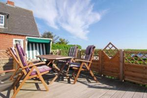 three chairs and a table on a deck at Wodan, Whg 1 in Tinnum +16 photos
