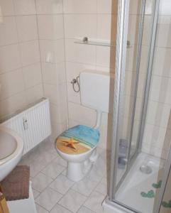 a bathroom with a toilet with a starfish on the seat at Ferienhaus Albrecht - ABC207 in Wismar
