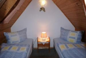 two beds in a room with a lamp on a table at Ferienhaus Albrecht - ABC207 in Wismar