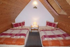 two twin beds in a attic room with a lamp at Ferienhaus Albrecht - ABC207 in Wismar