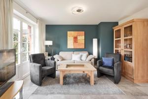 un soggiorno con divano, 2 sedie e tavolino da caffè di Haus Kastanie a Boldixum