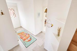 un corridoio bianco con un tappeto sul pavimento di Haus Kastanie a Boldixum