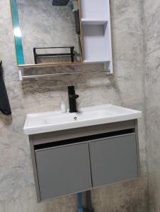 een witte wastafel in een badkamer met een spiegel bij BP family room 4 in Ko Mak