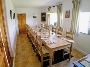 een lange eetkamer met een lange tafel en stoelen bij Purcombe Farmhouse - 28458 in Whitchurch Canonicorum