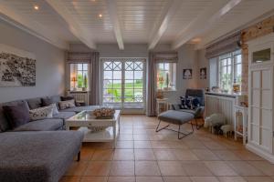 a living room with a couch and a table at Hüs Leen in Hedehusum +24 photos