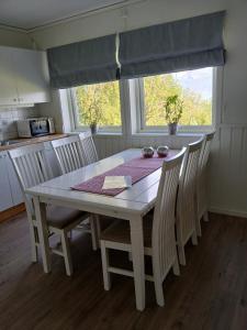 een eettafel met stoelen en een raam bij Solbakken 27 Apartment in Lyngseidet
