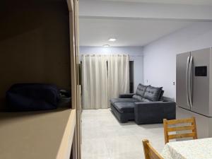 a living room with a couch and a refrigerator at Recanto perto do mar com Jacuzzi in Camboriú