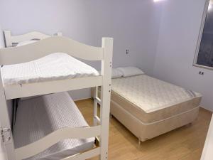 a couple of bunk beds in a room at Recanto perto do mar com Jacuzzi in Camboriú