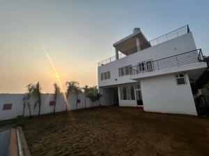 un grand bâtiment blanc avec un coucher de soleil en arrière-plan dans l'établissement Mangal Uday Villa, à Jaipur 18 autres photos