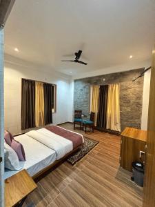 une chambre avec un grand lit et un mur en pierre dans l'établissement Mangal Uday Villa, à Jaipur