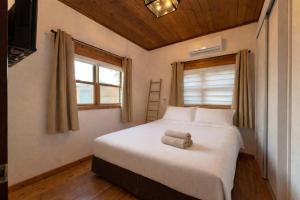 una camera da letto con un letto bianco con un asciugamano sopra di Villa Gshur a Eli Ad