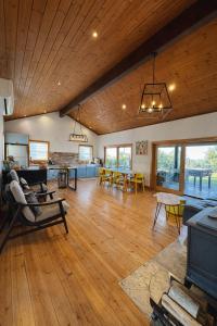 un ampio soggiorno con pavimenti in legno e una sala da pranzo di Villa Gshur a Eli Ad