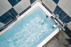 een bad gevuld met water en een kraan bij BEB5 Tsuchiura by Hoshino Resorts in Tsuchiura