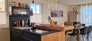 a kitchen with a black counter top and a table at Reethaus "Dat Lavendelhus" in Zierow