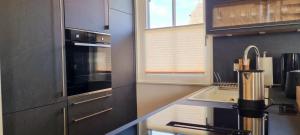a kitchen with a sink and a stove top oven at Reethaus "Dat Lavendelhus" in Zierow