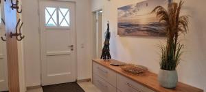 a room with a wooden dresser with a plant on it at Reethaus "Dat Lavendelhus" in Zierow