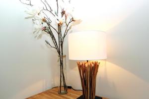 eine Lampe und eine Vase mit Blumen auf dem Tisch in der Unterkunft Syltrose in Hörnum