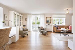 a living room with a kitchen and a living room with a couch at Hüs Freesenborg in Oldsum