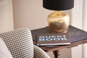 a guest book and a lamp on a table with a guest book at Hüs Freesenborg in Oldsum